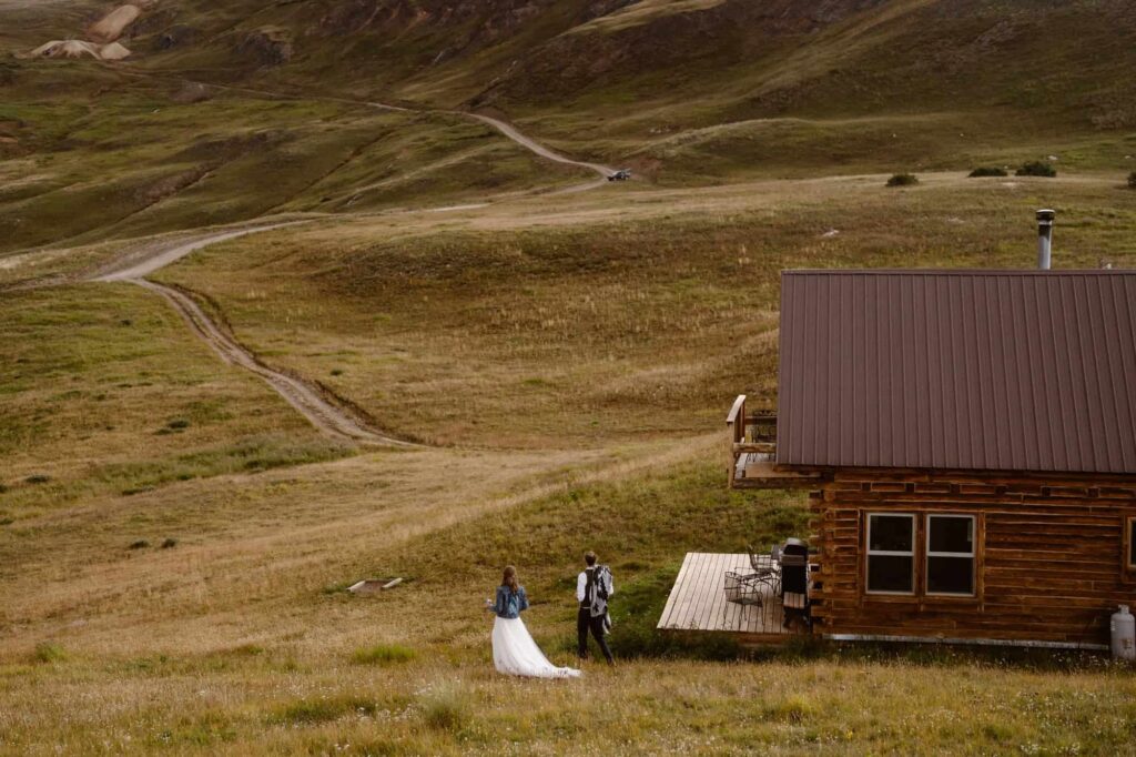 Bride and groom walking toward Colorado cabin