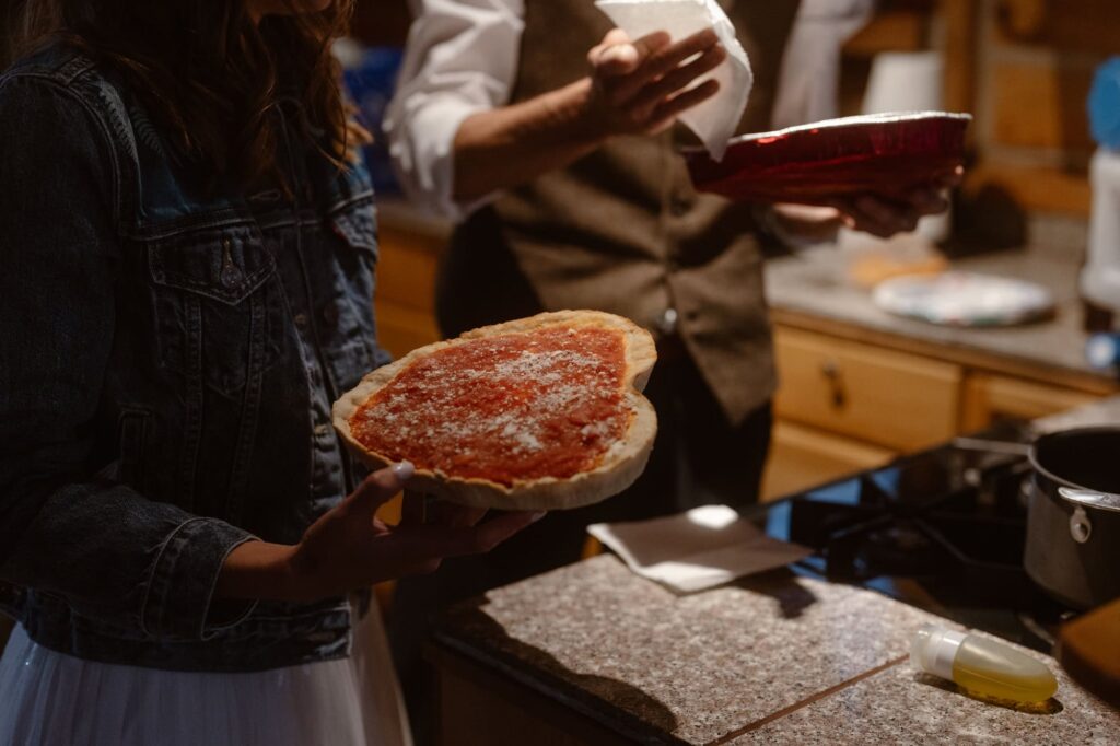 Bride and groom making pizza at wedding inside Colorado cabin