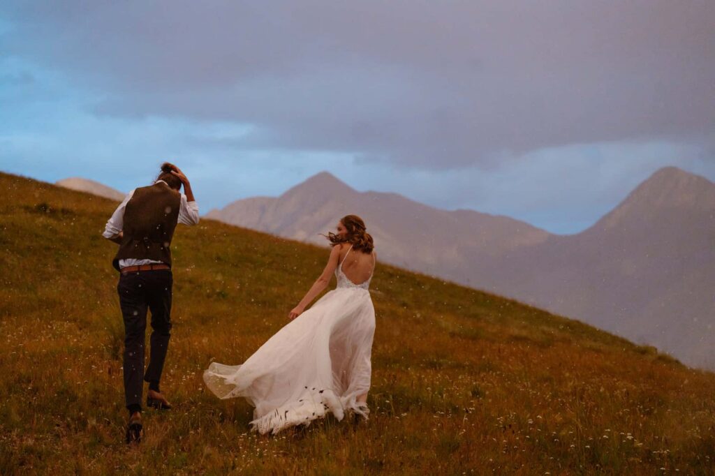 Bride and groom running through hail storm