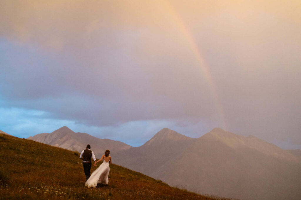 Sunset rainbow wedding photos outside of Colorado cabin