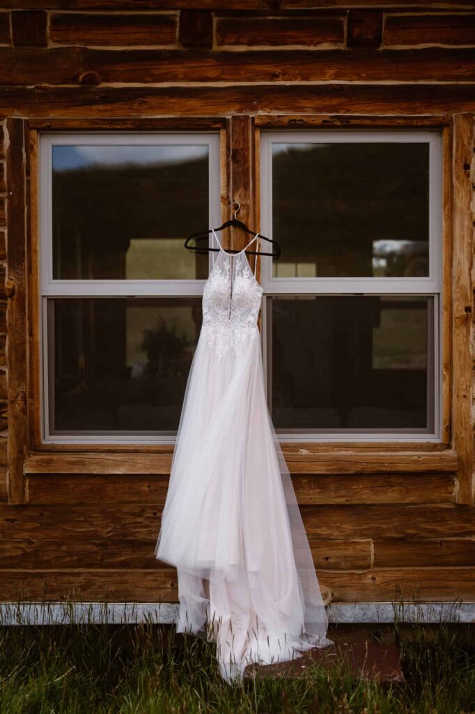 Wedding dress hanging on the side of a cabin in Colorado
