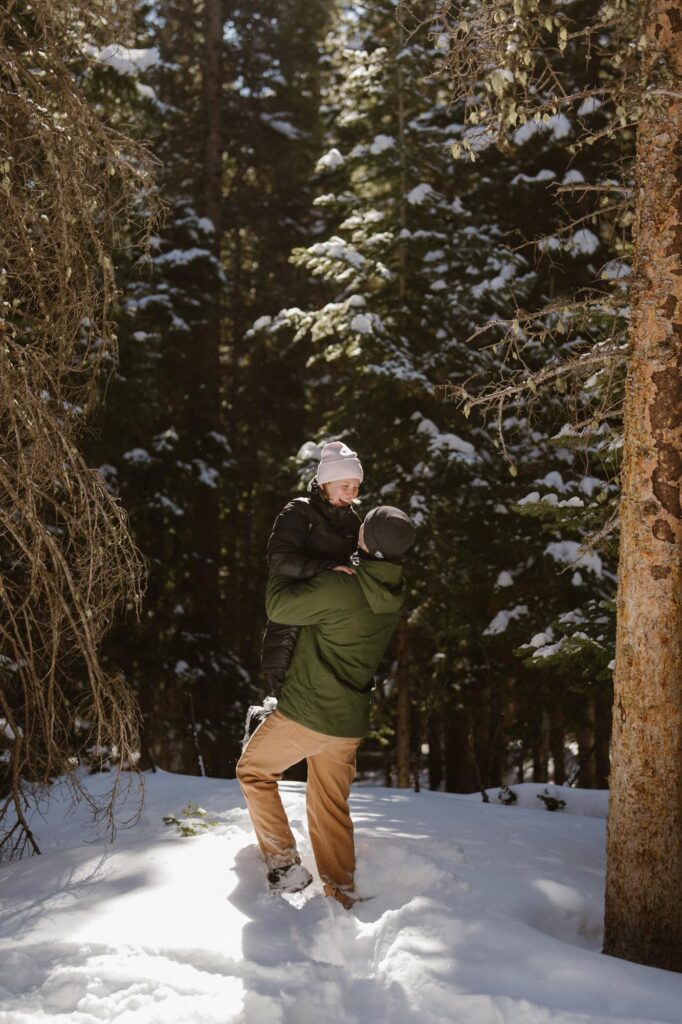 Couple playing in the snow in Rocky Mountain National Park