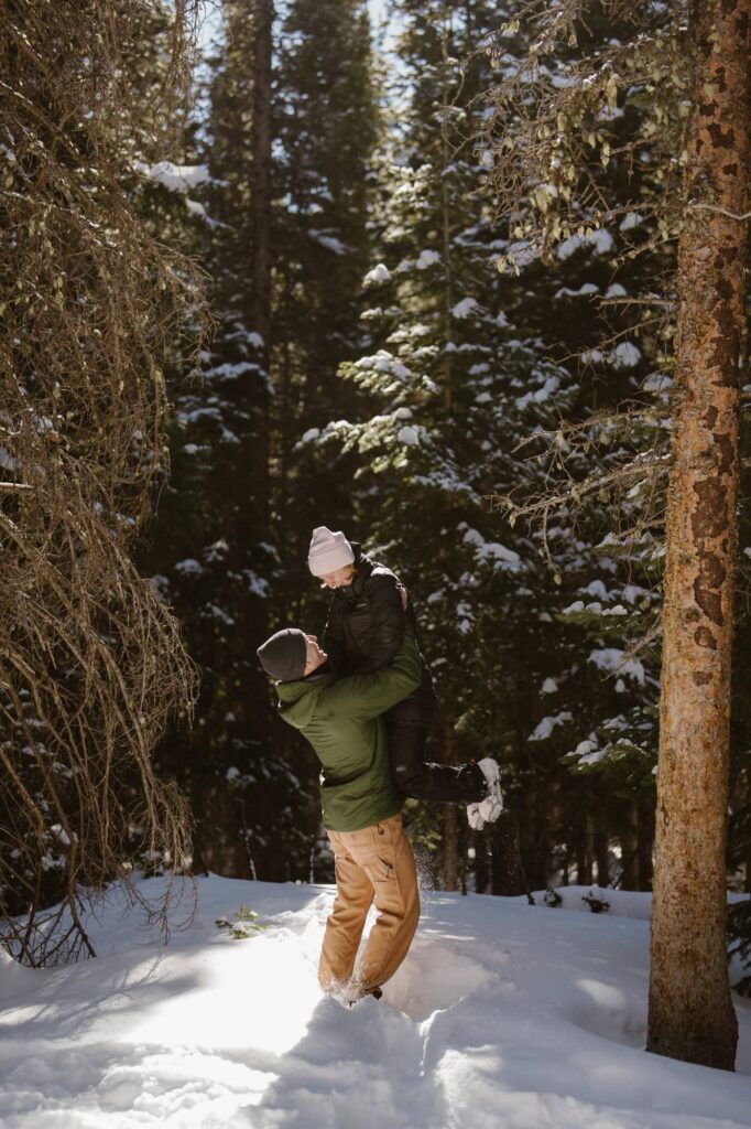 Couple in the snowy forest in Rocky Mountain National Park during hiking proposal