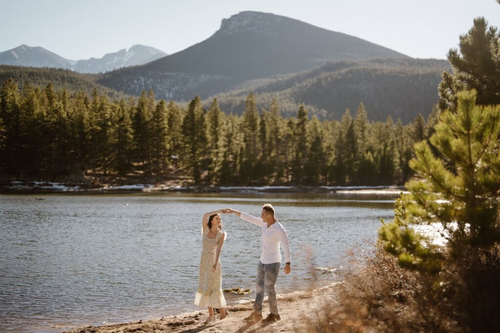 Couple dancing on the shore of Lily Lake with mountains in the distance
