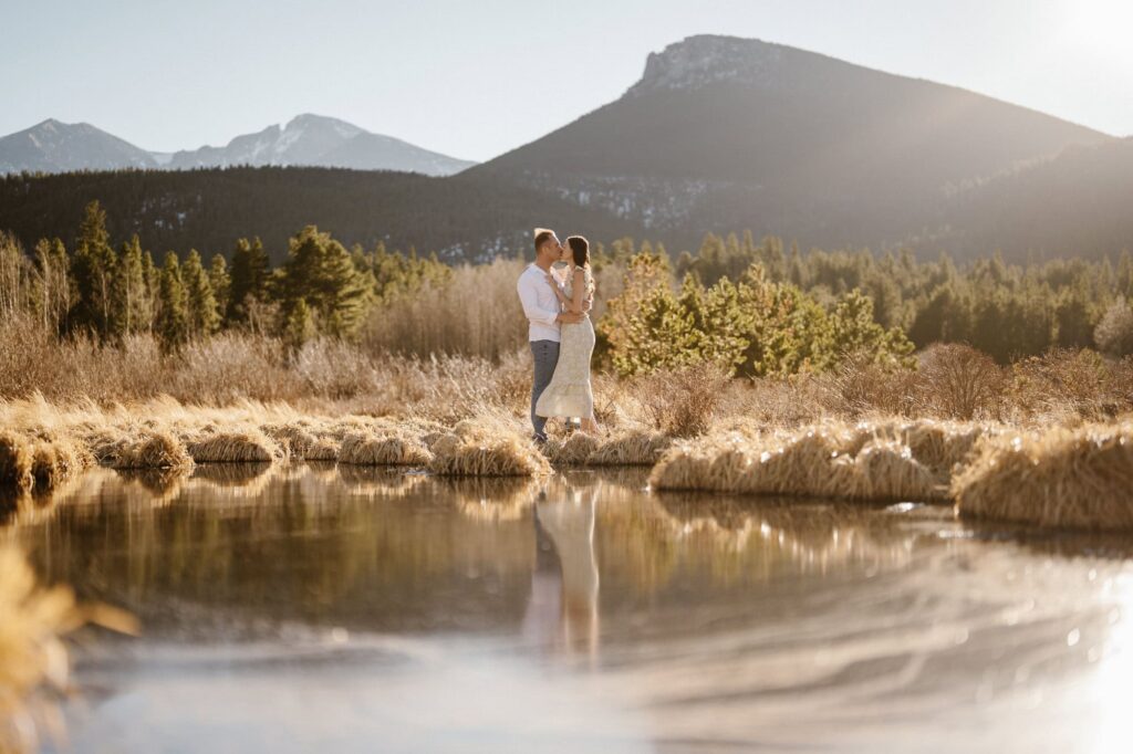 Couple kissing in the mountains with reflection on the water