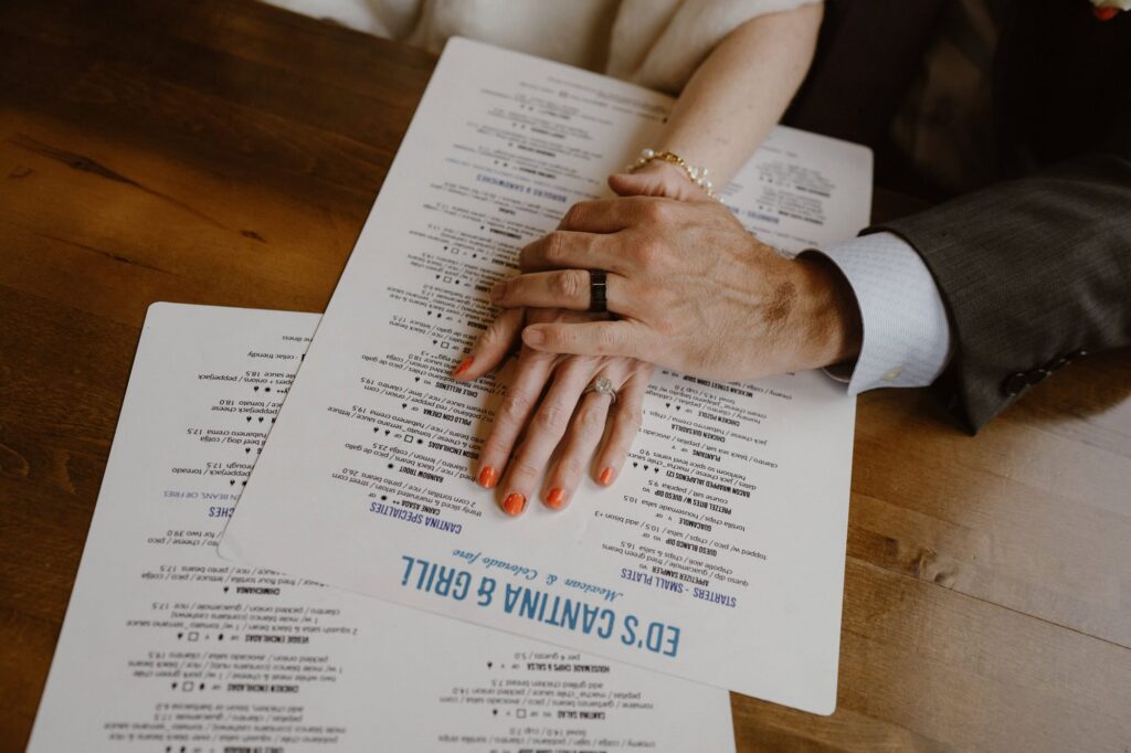 Bride and groom with their rings on the menu at Ed's Cantina