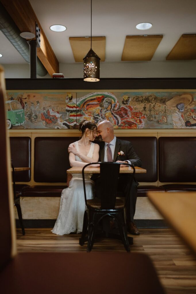 Bride and groom in booth at Ed's Cantina in Estes Park