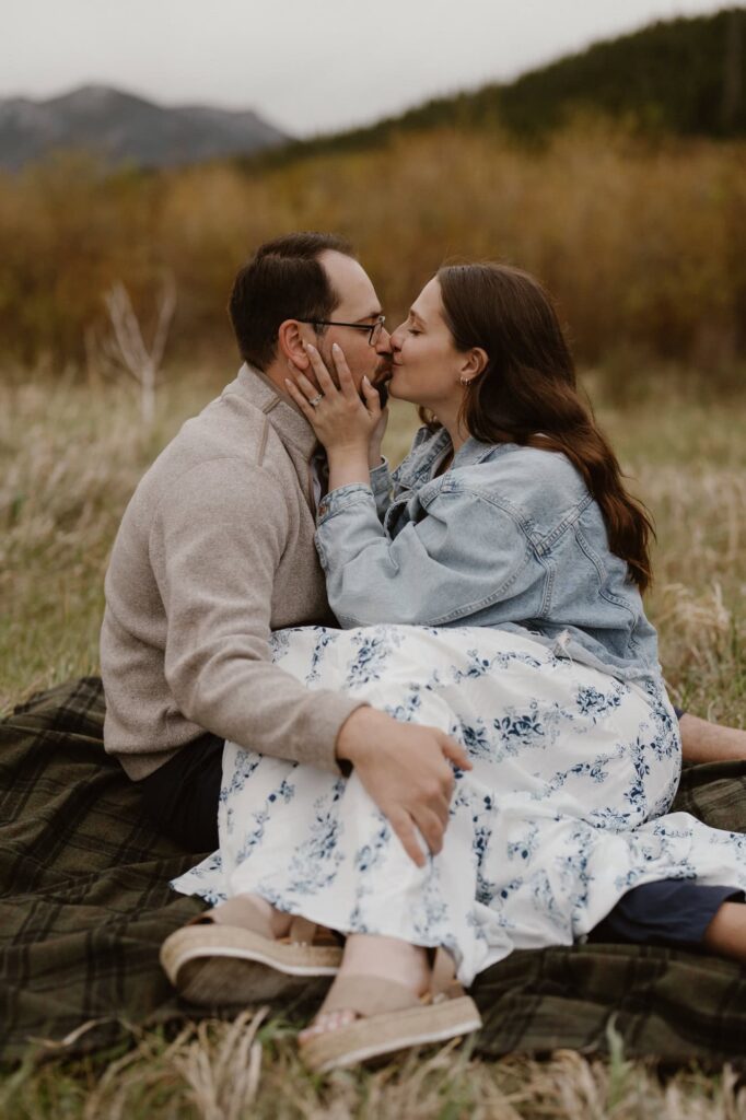 Couple sitting on blanket in a mountain meadow