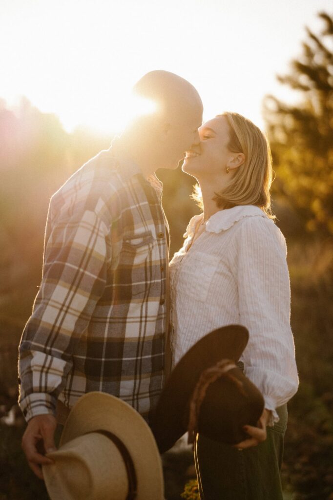 Engagement photos with cowboy hats as the sun comes up in Rocky Mountain National Park