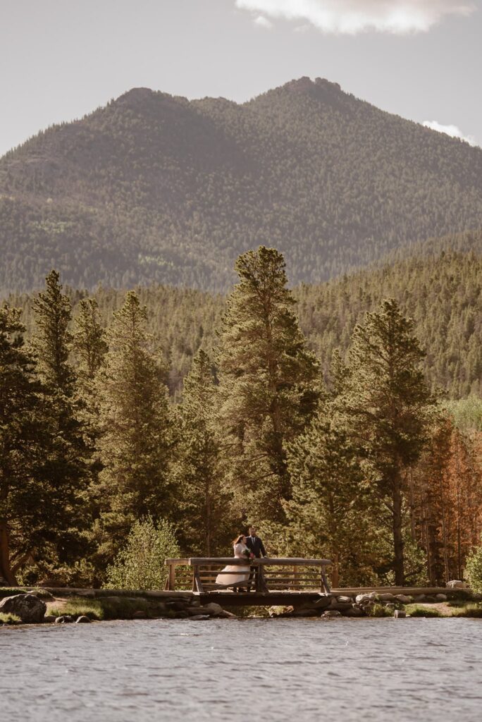 couple standing on a bridge at Sprague Lake in Rocky Mountain National Park
