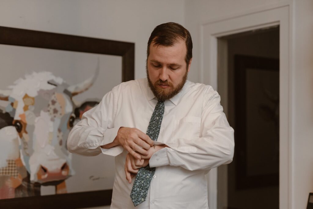 Groom getting ready for his wedding day at Airbnb in Estes Park Colorado