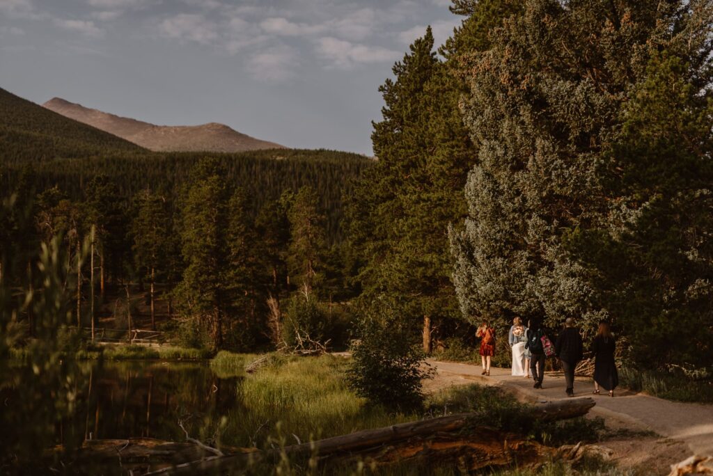 Family walking the flat path to Sprague Lake for a wedding ceremony