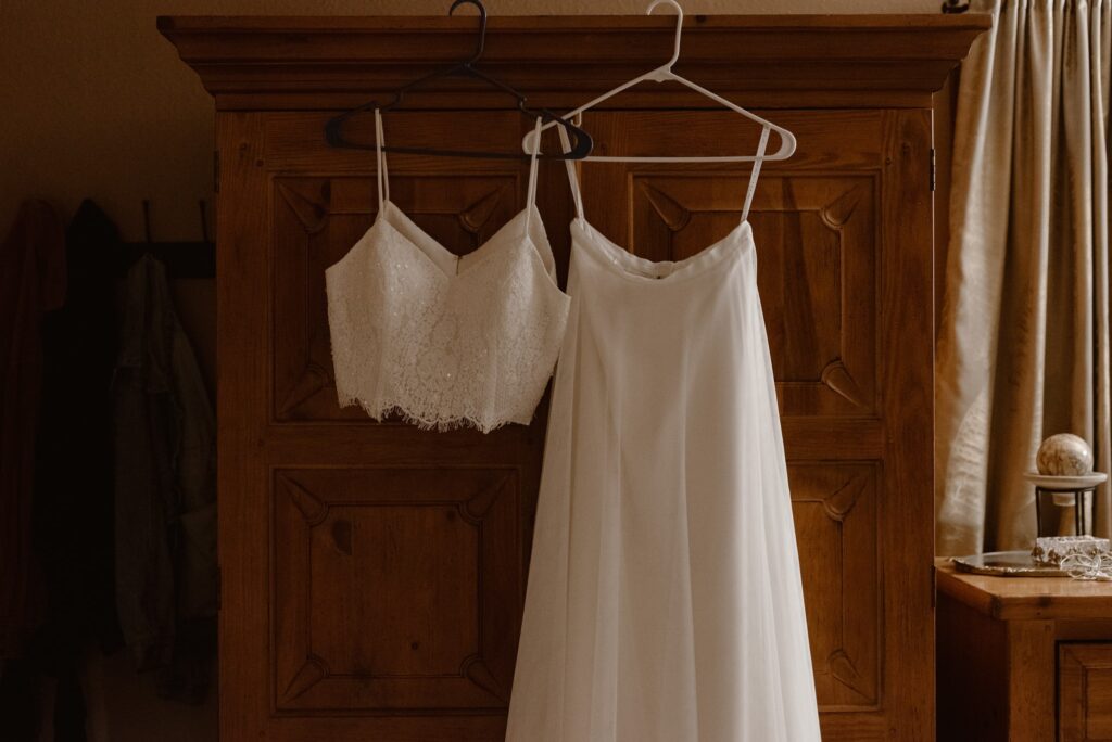 Wedding dress hanging from wooden armoire