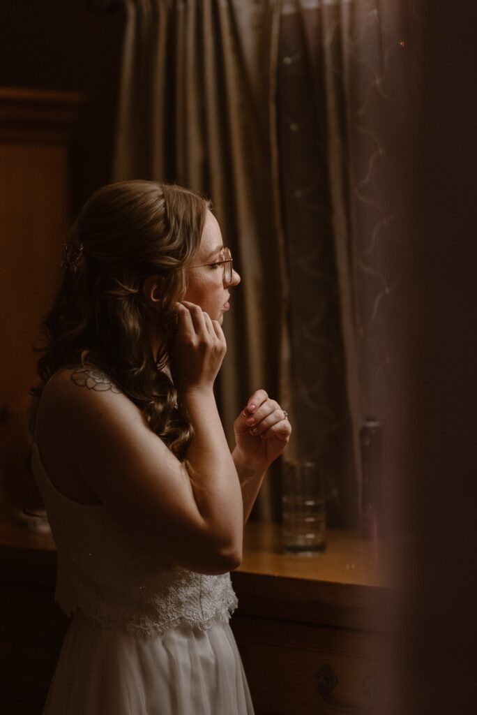 Bride putting in earrings on her wedding day