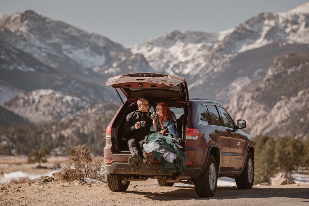 Couple drinking coffee in the back of their Jeep after getting married in Rocky Mountain National Park