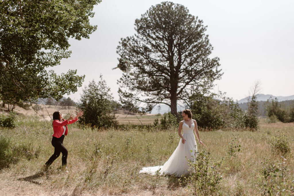 Bride throwing bouquet to wedding guest in the meadows of Rocky Mountain National Park