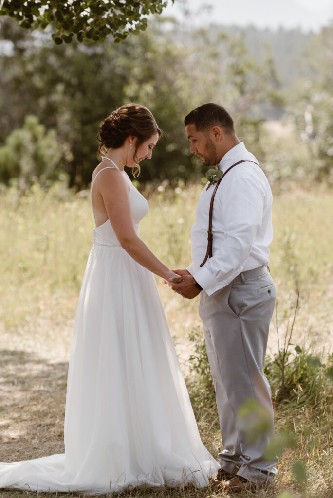 Emotional first look between bride and groom in a meadow