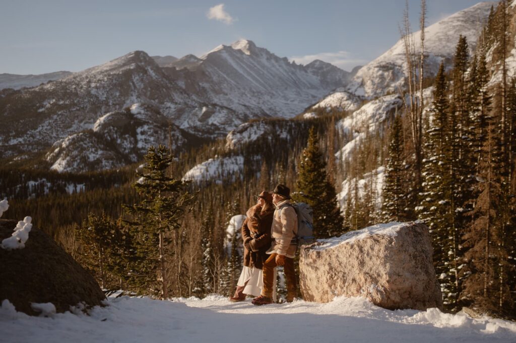 Couple gazing off into the distance with snowy mountain peaks in the background