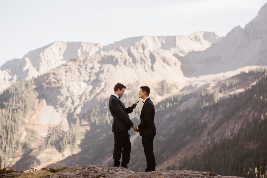 two grooms exchanging vows in the mountains of colorado