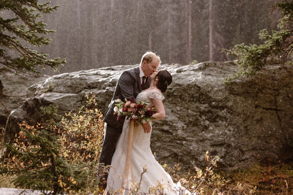 Elopement photographer captures couple kissing in the rain on their elopement day in Rocky Mountain National Park