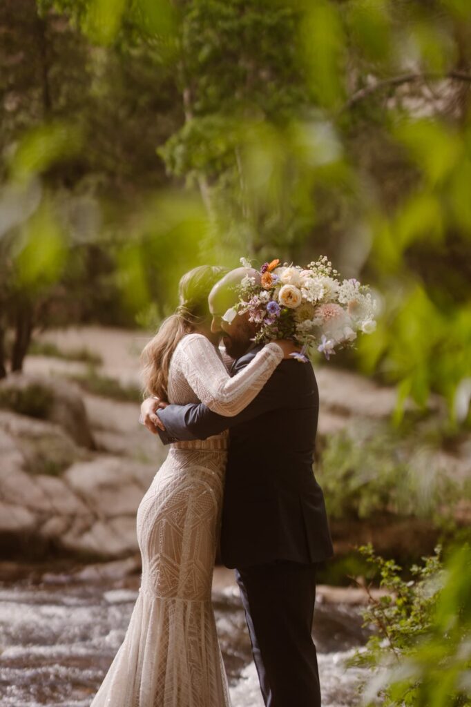 bride and groom hugging with Marigold bouquet 