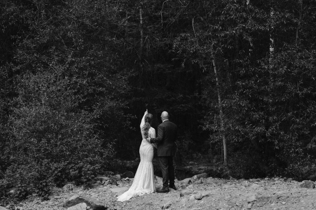 black and white photo of couple on the edge of the forest