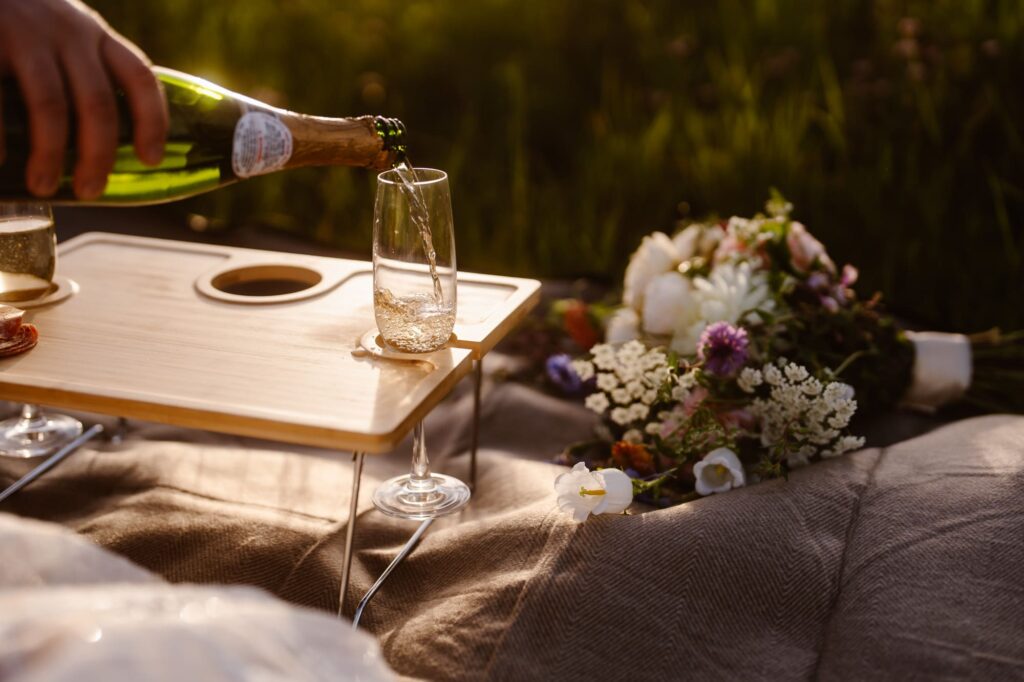 pouring a champagne picnic at the couples June Colorado elopement