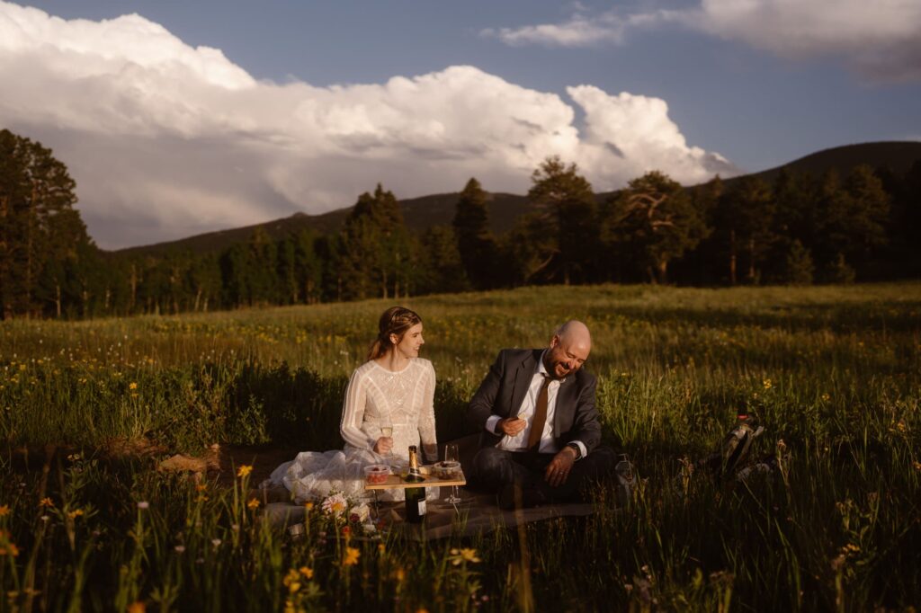 couple laughing in a meadow of wildflowers at their June elopement