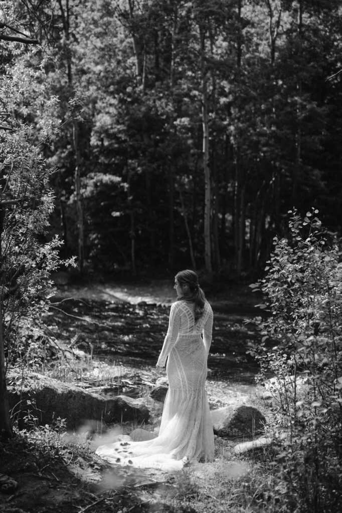 black and white photo of bride along stream