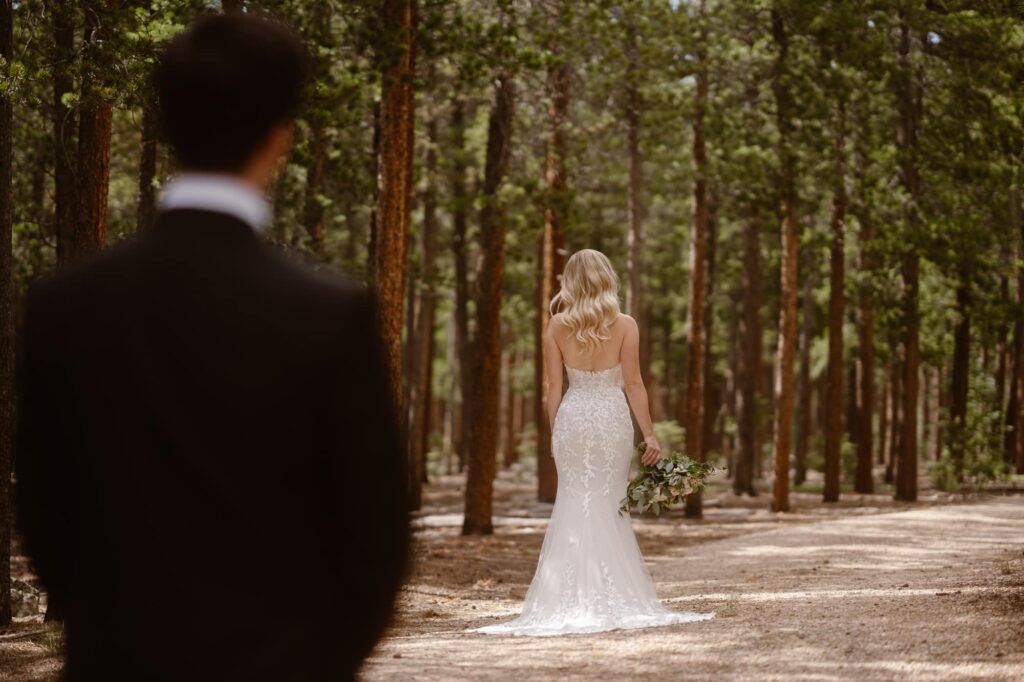 Bride and groom on a dirt road in a wooded area