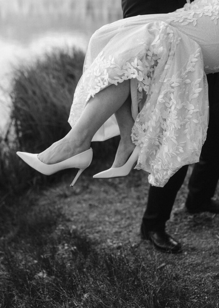 black and white photo of wedding heels and dress