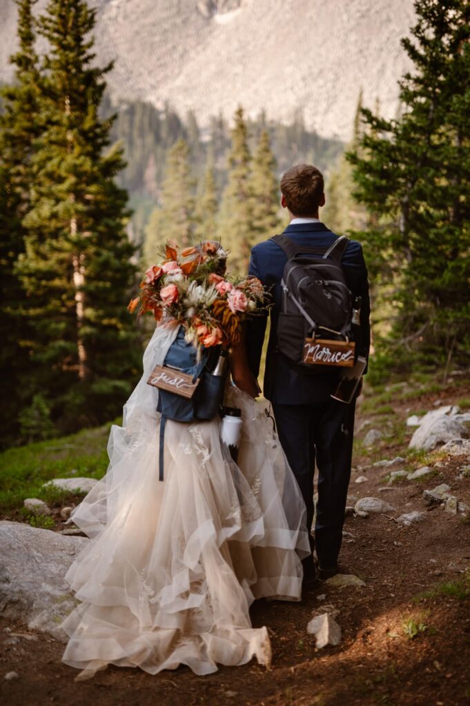 Just Married sign of couple hiking down from a mountain lake on their elopement day
