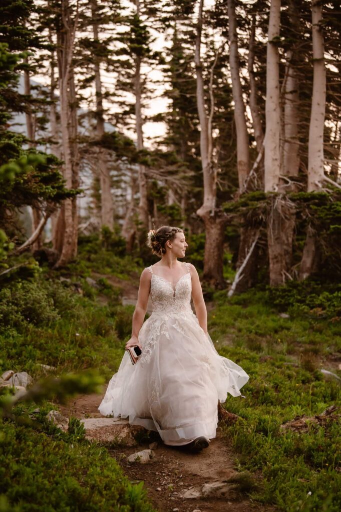 bride walking down forest trail to the first look