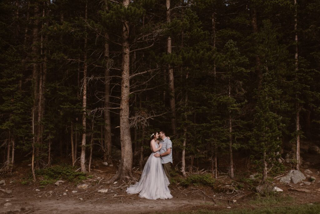 Couple on the edge of a forest during their hiking elopement in Colorado