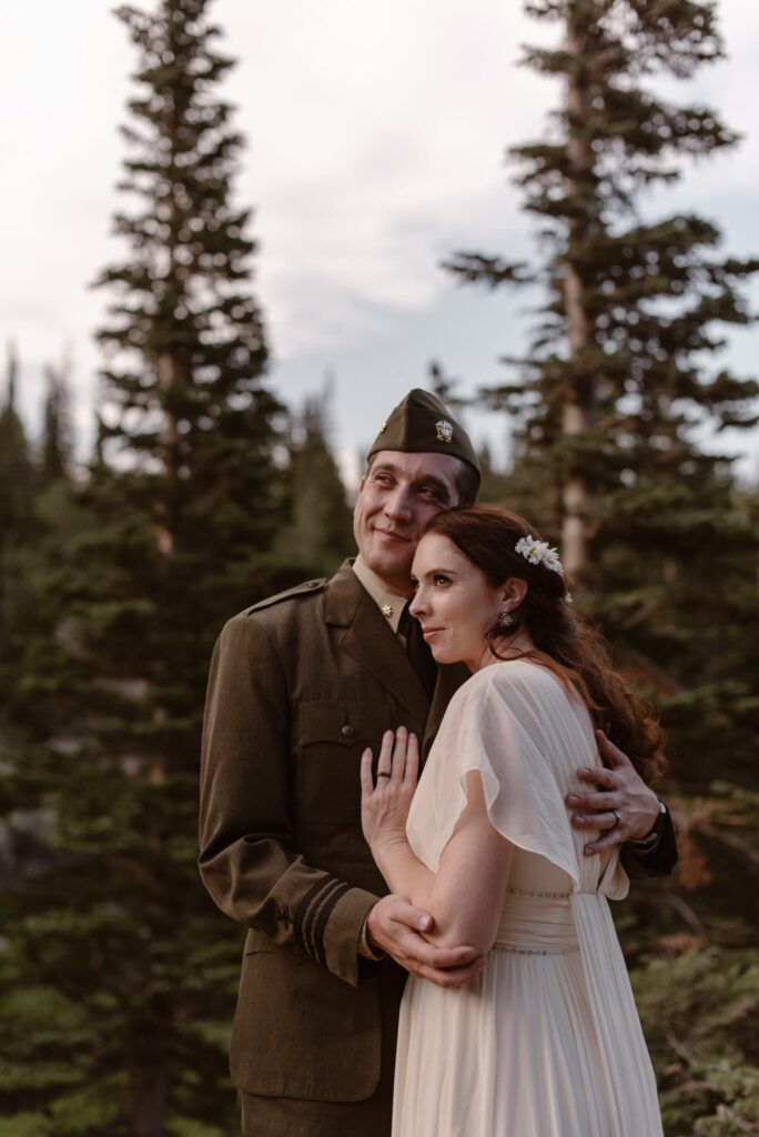 Groom in military outfit with bride for their wedding portraits