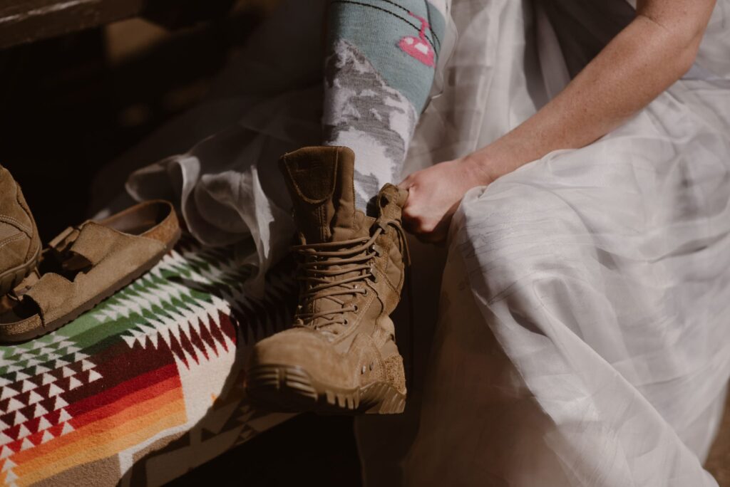 bride putting on her military wedding boots