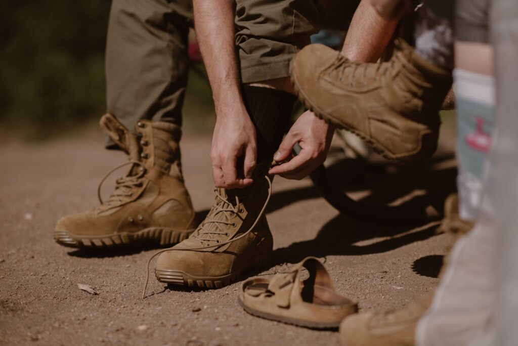 groom lacing up his military boots for wedding photos