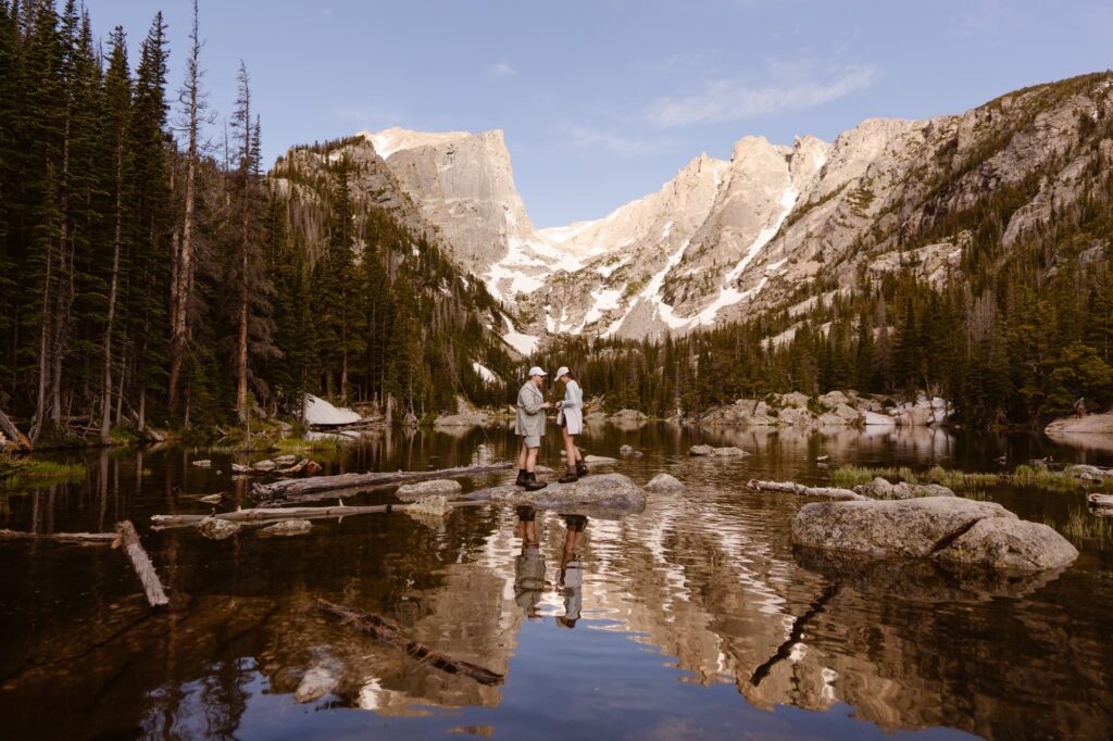 Couple after just getting engaged with Dream Lake and mountains in the backgroun