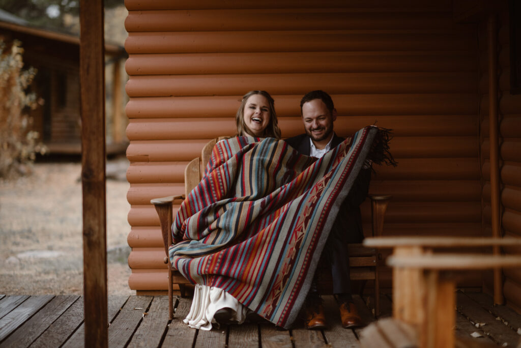 Couple laughing on the porch of their cabin