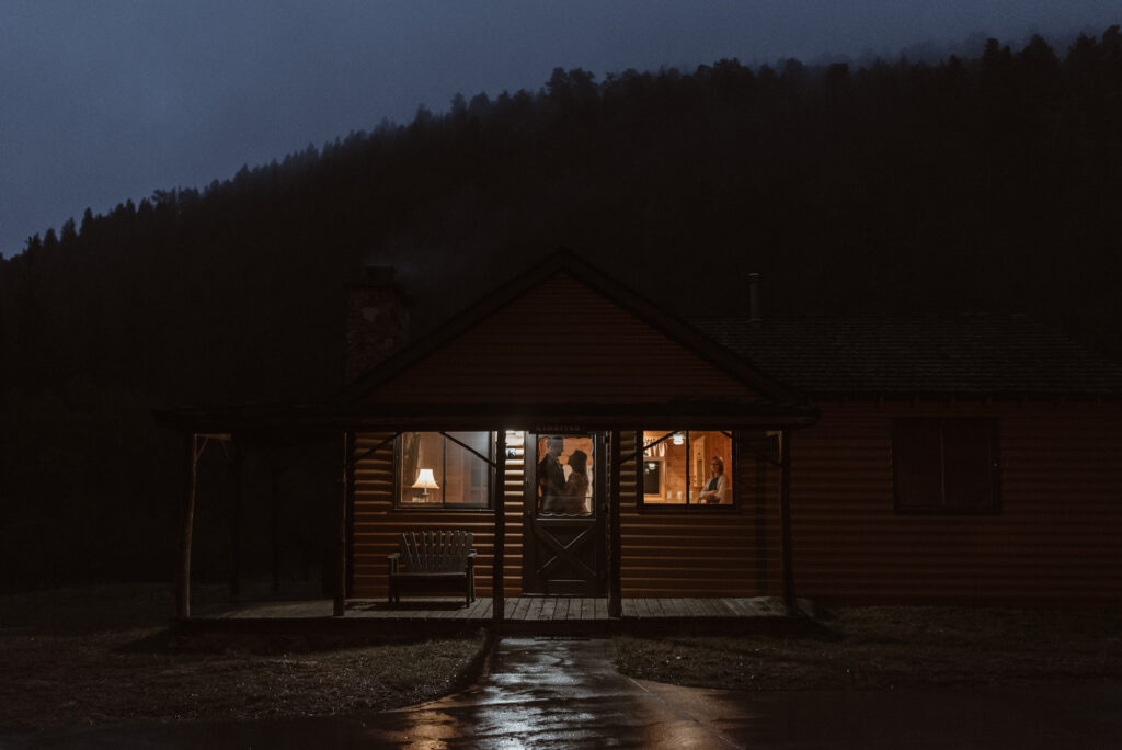 Couples silhouette in the window of their Estes Park cabin at the end of their wedding day