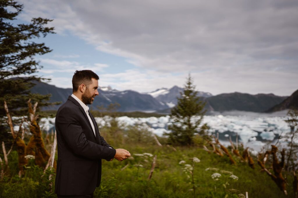 Groom getting ready on the porch of the yurt during Alaska helicopter elopement
