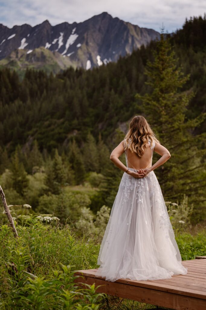 Bride putting on wedding dress in Alaska