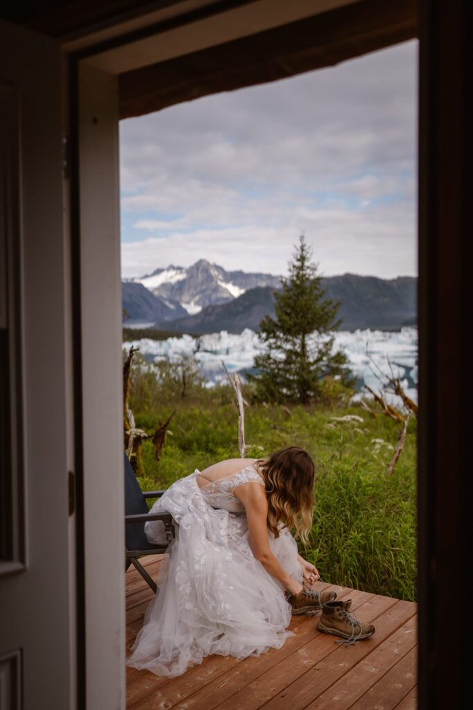 Bride lacing up hiking boots before Alaska helicopter elopement
