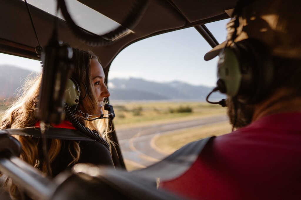 Couple flying in a helicopter on the way to their Alaska elopement