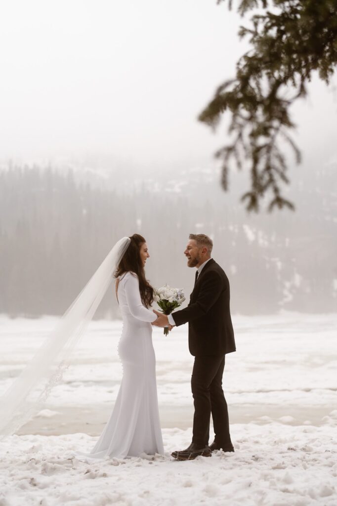 Bride and groom share first look on the shore of Bear Lake in RMNP