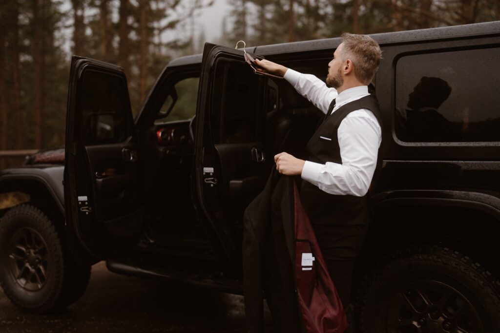 Groom getting ready at Jeep for wedding day in Rocky Mountain National Park
