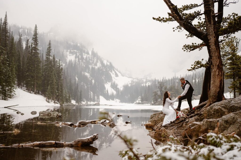 Couple on the shore of snowy Dream Lake in May