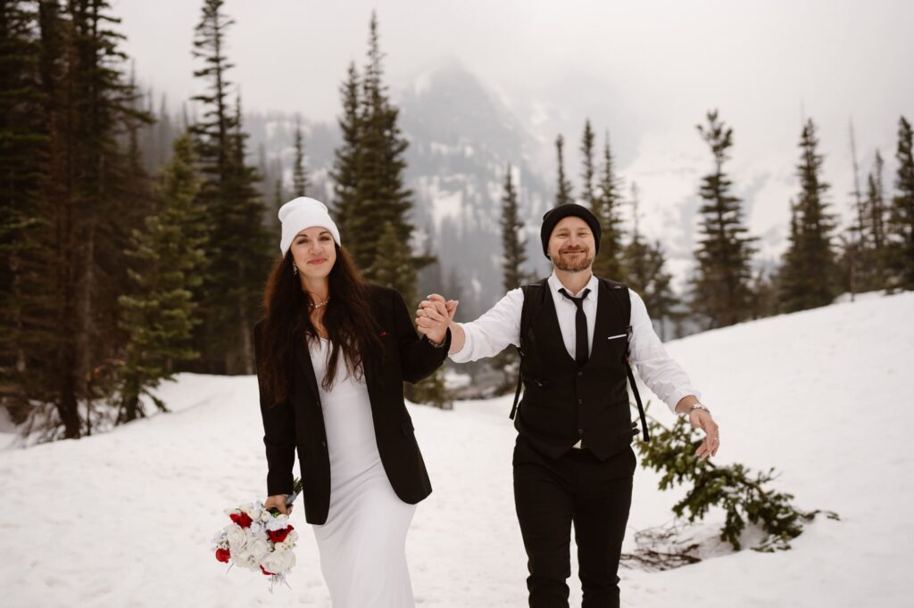 Couple walking in the snow at Dream Lake after elopement ceremony