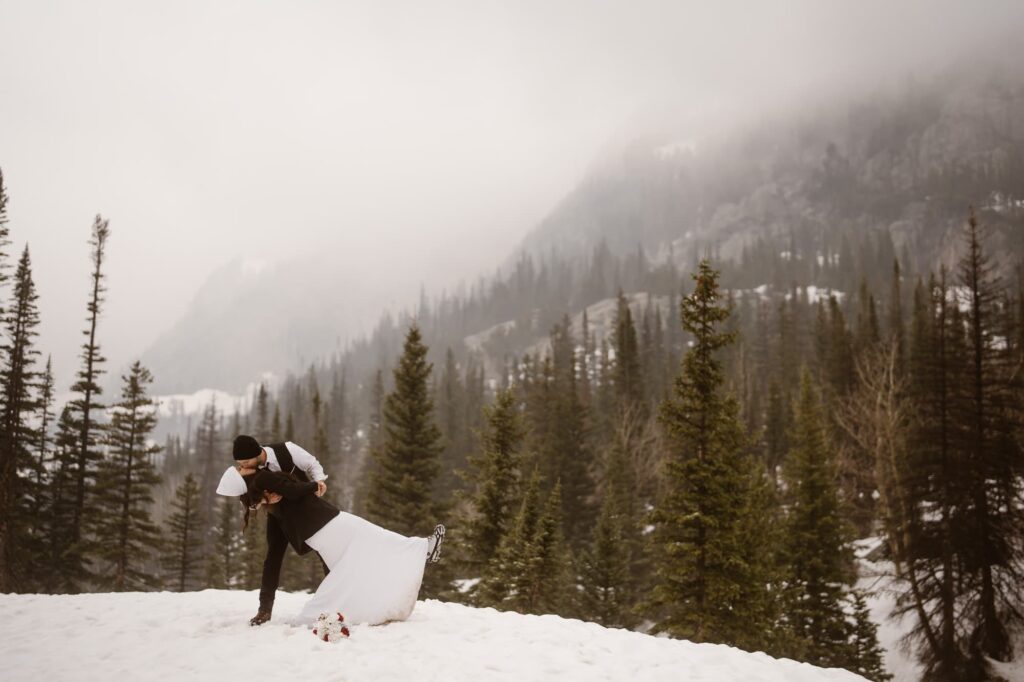 Couple dipping on top of a snowy mountain