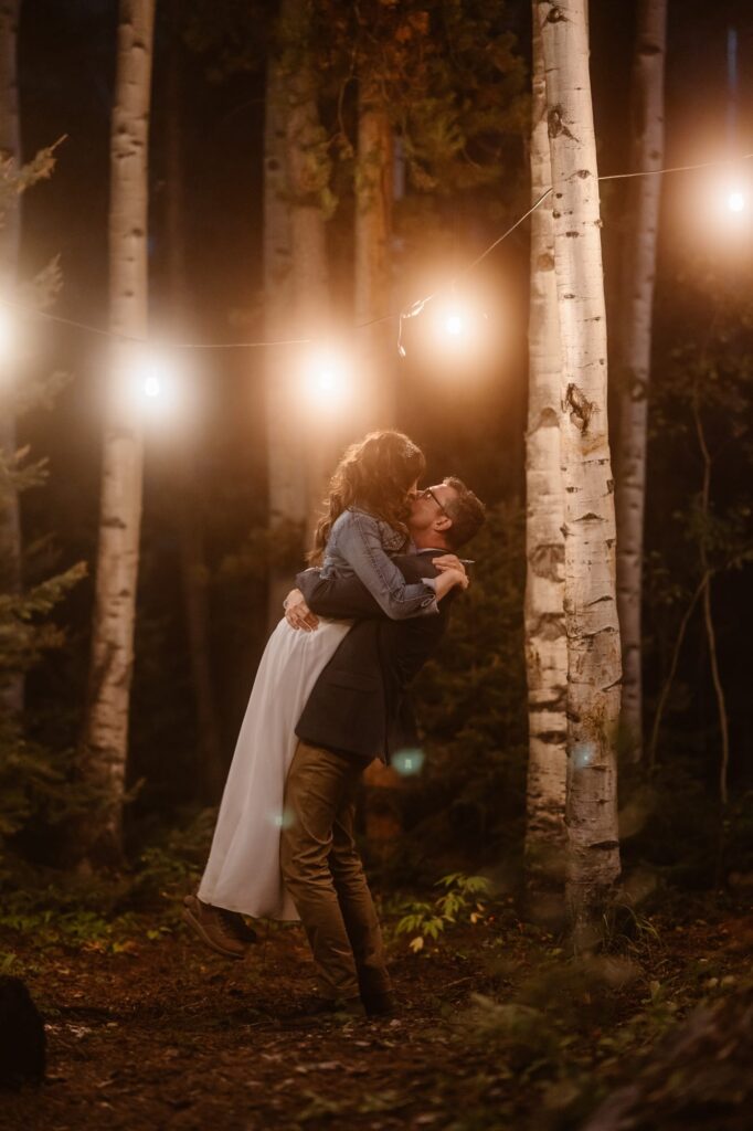 Couple kissing under the market lights in the forest
